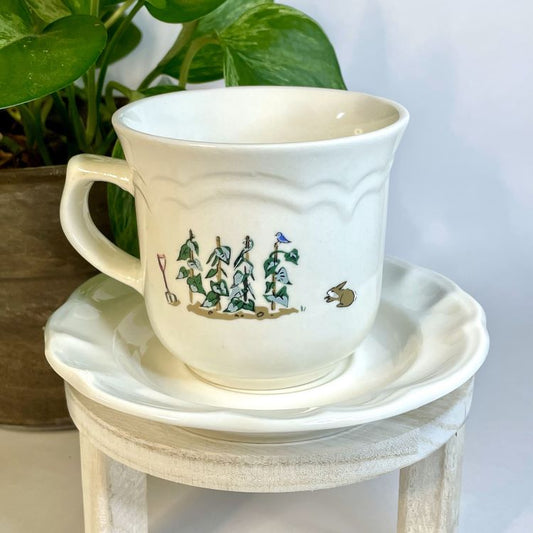 White ceramic cup and saucer with decorative elements on a white surface.