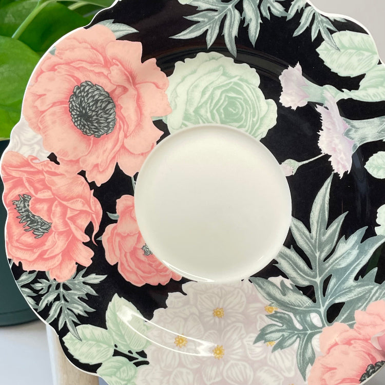 Decorative saucer with floral design on a black background