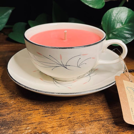 Candle in a teacup with a tag on a wooden surface
