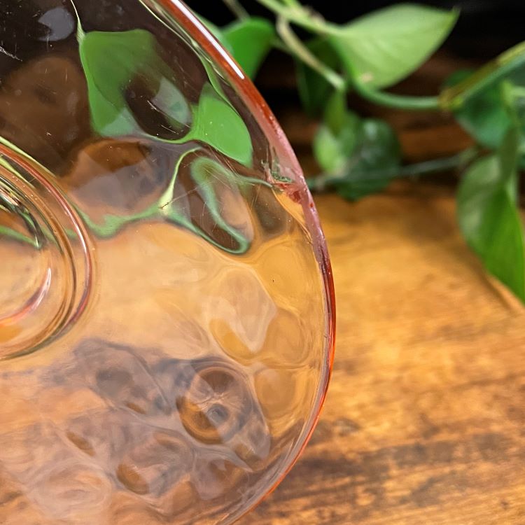 Closeup of a chip in a glass teacup saucer.