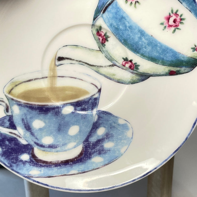 Ceramic saucer with teapot and cup and polka dot design.